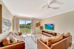 a living room with two couches and a tv at Sunrise Suite Central to I75 airport & downtown in Punta Gorda