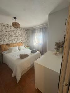 a bedroom with a large white bed and a desk at La Casa del Pueblo con piscina y barbacoa in Rincón de Ballesteros +29 photos