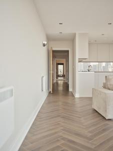 ロンドンにあるExcel Luxury Apartment with amazing viewの白いリビングルーム(ソファ付)、キッチンが備わります。 +6枚の写真