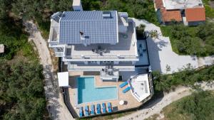 Una vista aérea de una casa con piscina. en Gigi Star Luxury ApartVilla with Pool, Panoramic Sea View, en Tsilivi