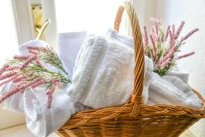 ein Korb mit Handtüchern und Blumen auf einem Tisch in der Unterkunft Le Sciosce in San Giorgio Lucano