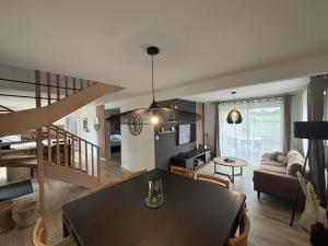 a living room with a table and a dining room at la maison du bord de mer in Penvénan