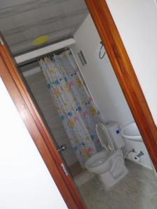 Un baño con inodoro y cortina de ducha. en El Apartastudio de Dña Gilma en Pijao, en Pijao