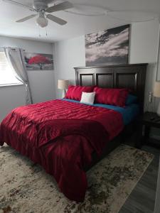 a bedroom with a bed with red sheets and a ceiling fan at Purple Mountain Majestic Retreat in Colorado Springs