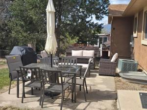 a patio with a table and chairs and an umbrella at Purple Mountain Majestic Retreat in Colorado Springs
