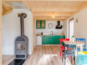 una cucina con fornelli e un tavolo con sedie di Zagroda ciszy a Lubiatowo Altre 14 foto