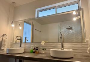 two sinks in a bathroom with a large mirror at Comunidad Calle 13 Hotel Boutique in Santa Marta +64 photos