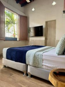 サンタ・マルタにあるComunidad Calle 13 Hotel Boutiqueの大きなベッドとテレビのある寝室