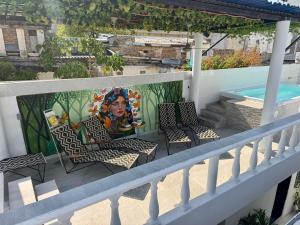 a mural on a balcony with chairs and a pool at Comunidad Calle 13 Hotel Boutique in Santa Marta