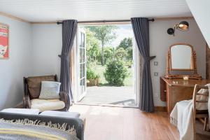 a living room with a door open to a yard at Broomfeild Bothy Comes with a Sauna in Boat of Garten