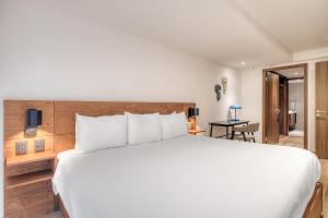 a bedroom with a large white bed and a desk at Urban Reforma Mexico City by Lumina in Mexico City