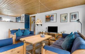 BolilmarkにあるHoliday Home Romo With Sauna 331のリビングルーム(青いソファ、木製テーブル付)