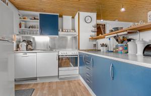 BolilmarkにあるHoliday Home Romo With Sauna 331の白いキャビネットと青いカウンター付きのキッチン +11枚の写真