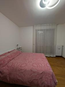 La casa di Mirco F1 في إيمولا: غرفة نوم بها سرير وبطانية حمراء