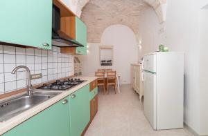 a kitchen with green cabinets and a white refrigerator at Palazzo Lama in Martina Franca