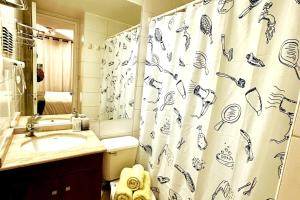 a bathroom with a shower curtain with a sink at Santiago Urbano Apartments - Centric Santiago in Santiago +6 photos
