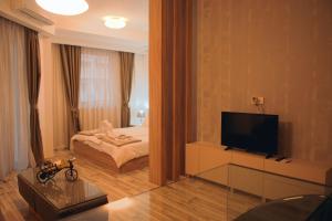 a living room with a bed and a television at Ohrid Luxury Studios in Ohrid