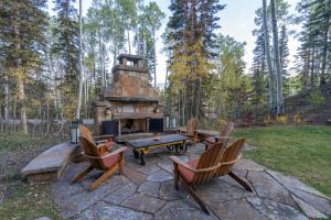 a stone fire pit with chairs and a table and a table at Alpenglow by Exceptional Stays in Telluride