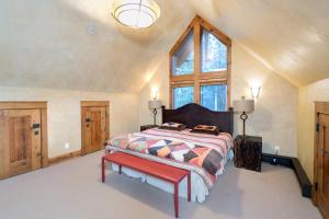 a bedroom with a bed with a red bench and a window at Alpenglow by Exceptional Stays in Telluride +17 photos