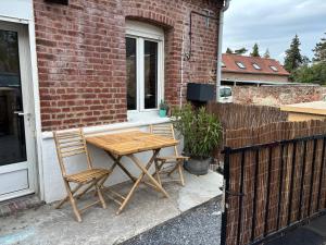 a wooden table and two chairs on a patio at A la ferme eight in Récourt
