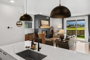 a kitchen with a sink and a living room at Gateway to Yellowstone in Livingston
