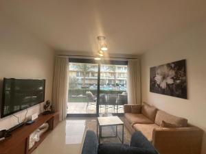 a living room with a couch and a tv at Hotel apartment in G cribs 2BR in El Gouna