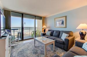 a living room with a couch and a table at Pelican Watch 302 by Carolina Beach Realty in Carolina Beach