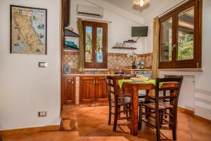 a kitchen with a wooden table and chairs at Villa Elena vicino la Riserva naturale dello Zingaro in Scopello +26 photos