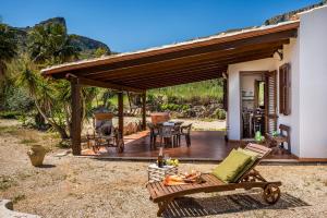 a porch with a deck with a table and chairs at Villa Elena vicino la Riserva naturale dello Zingaro in Scopello