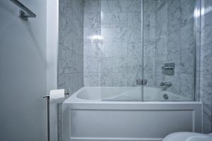a white bathroom with a tub and a shower at The York I in Toronto +29 photos