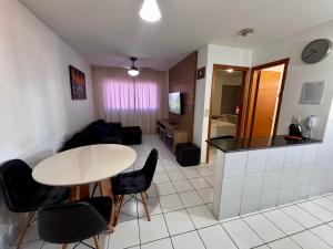 a kitchen and a living room with a table and chairs at Apartamentos Renovatio Jatiuca - Castelo B Temporada in Maceió