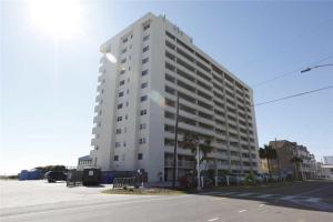 a tall white building on the side of a street at Pelican Watch 706: Sea You Next Time by Carolina Beach Realty in Carolina Beach