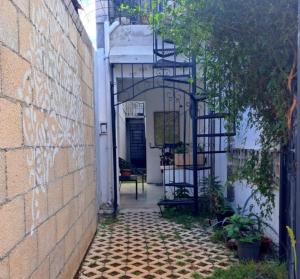 an empty alley with a brick wall and a black ladder at Casa Ha Hostal in Mérida
