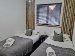 une chambre avec deux lits avec des serviettes dessus dans l'établissement Bungalow 62,North Cornwall, St. Tudy, à Saint Tudy