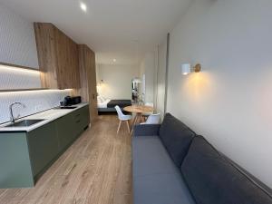 a living room with a couch and a kitchen and a table at Apartamentos Nou Mestalla in Valencia