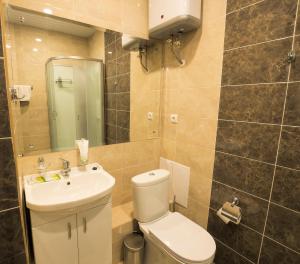 a bathroom with a toilet and a sink and a mirror at Apartment on Alekseyeva, 49 by KrasStalker in Krasnoyarsk