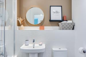a bathroom with a sink and a mirror and a toilet at Penthouse Apartment - City Centre - Secure Parking, Balcony, Self-Check-In, Fast Wifi and Smart TV with Netflix by Yoko Property in Milton Keynes