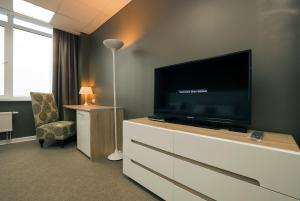 a hotel room with a flat screen television on a dresser at Apartment on Alekseyeva, 49 by KrasStalker in Krasnoyarsk