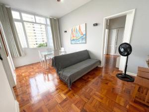 un salon avec un canapé et une table dans l'établissement Apê Vista Mar - 50m da Praia Pitangueiras, à Guarujá