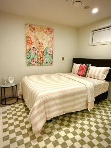 a bedroom with a bed with a painting on the wall at 2Bedrooms,SkyTower next 20 m, FREE parking, Air con in Auckland