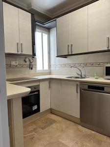 a kitchen with white cabinets and a sink at 5 Caballeros in Puente Genil