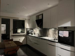a kitchen with white cabinets and a sink and a window at Cozy Central Apartment in Basel