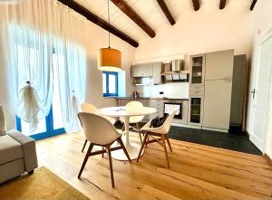 Una cocina y un comedor con mesa y sillas. en Casa De la Luz, en Siracusa