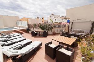 a patio with chairs and tables on a roof at Apartamentos Salamanca in Málaga