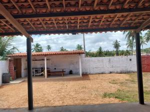 an outside view of a house with a bench at Casa Praia Milagres in São Miguel dos Milagres