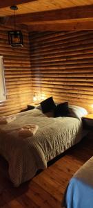 a bedroom with a large bed with a wooden wall at Cabañas Olavarría in Olavarría +14 photos