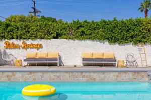 Una piscina con dos tumbonas y una balsa amarilla. en Lemon Twist by ACME House Company, en Palm Springs