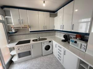 a kitchen with white cabinets and a sink and a dishwasher at Casa val in Valdemoro +15 photos
