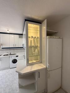 a white kitchen with a refrigerator and a microwave at Casa val in Valdemoro
