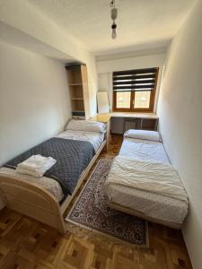 two beds in a small room with a window at Casa val in Valdemoro